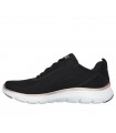 Deportivo Skechers en color negro con cierre de cordones y suela blanca.