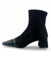 Botines con corte elástico y puntera de charol en color negro.